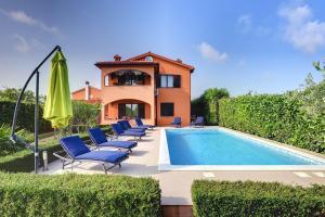 a villa with a swimming pool and chairs and a house at Apartment Sissano in Ližnjan