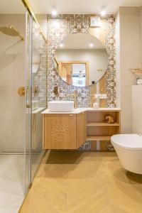 a bathroom with a sink and a mirror at Cyrhla Apartamenty - sauna, playroom, free parking & wifi in Zakopane
