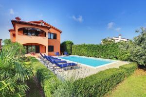 a villa with a swimming pool in front of a house at Apartment Sissano in Ližnjan +7 photos