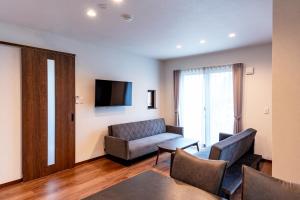 a living room with a couch and a tv at Villa Fuji-nishiki in Fujikawaguchiko