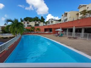 a large blue swimming pool next to a building at Studio vue sur la mer, piscine - L'Oasis de Tartane in La Trinité