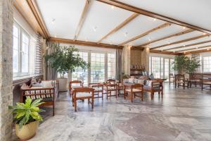 a large room with tables and chairs and windows at Pal Beach in Palaiochora