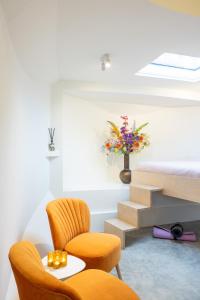 a room with two chairs and a table and a vase of flowers at Boat suite - A Unique Houseboat Stay in Amsterdam in Amsterdam