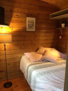 una camera da letto con un letto in una parete di legno di Jolie Roulotte tout confort a Saint-Amand-les-Eaux