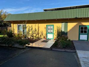 a small yellow house with a blue door at Gittis Condo in Kappeln