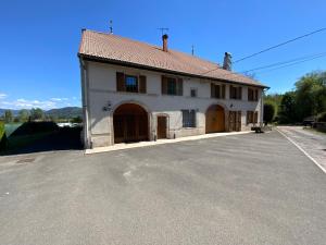a large white building with brown doors on a street at Gîte spacieux 8 personnes - Saint Joseph des Bruyères 1814 in Remiremont