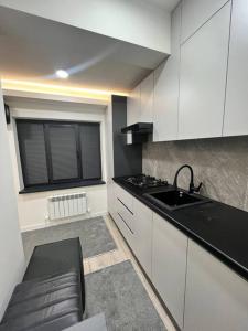 a kitchen with white cabinets and a sink and a window at New cozy apart in parkent street in Yalanghoch +4 photos