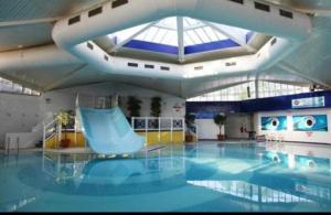 a swimming pool with a blue slide in a building at Caravan in Rockley Park 3 Bedrooms in Poole