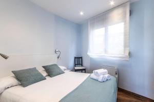 a bedroom with a bed with two towels on it at POLITXE Bermeo in Bermeo