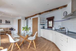 a kitchen with white cabinets and a table and chairs at POLITXE Bermeo in Bermeo