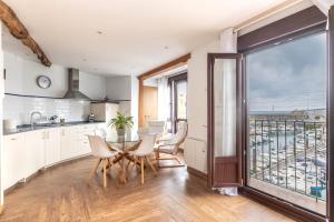 a kitchen with a table and chairs and a large window at POLITXE Bermeo in Bermeo +12 photos