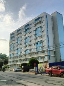 a large building with a red car parked in front of it at Executive Suite Condo 1 in Dumaguete