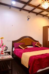 1 dormitorio con 1 cama grande con sábanas rojas en Cloudy Vista Kodai, en Kodaikanal