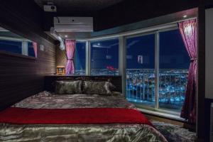 a bedroom with a bed and a window with a view at Meteor Shower in Sapporo