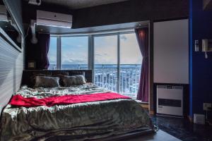 a bedroom with a bed and a large window at Meteor Shower in Sapporo