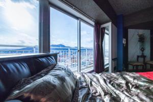 a bedroom with a bed and a large window at Meteor Shower in Sapporo