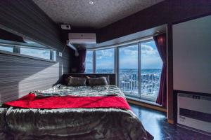 a bedroom with a bed and a large window at Meteor Shower in Sapporo