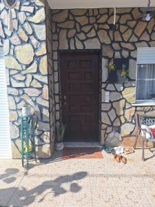 a stone building with a brown door and a chair at House Prosperity in Amora +4 photos