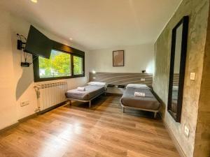 un soggiorno con 2 letti e una finestra di SOLOPUENT Hotel Rural a Castiello de Jaca Altre 60 foto