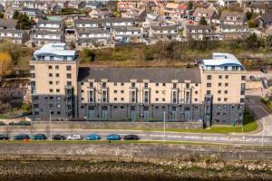 a large building with cars parked in a city at Riverside Lodge in Aberdeen