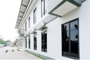 a facade of a building with large windows at Zumo Home Tegal Mitra RedDoorz in Tegal