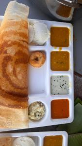 un plato de comida con pan y diferentes salsas en Cloudy Vista Kodai, en Kodaikanal