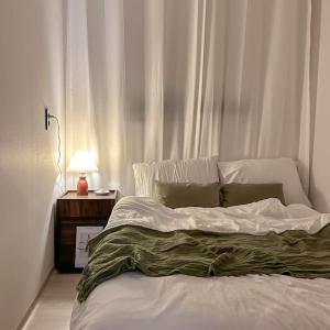 a bedroom with a bed and a night stand with a lamp at busan&u 2 in Busan