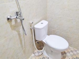 a bathroom with a toilet and a shower at Zumo Home Tegal Mitra RedDoorz in Tegal