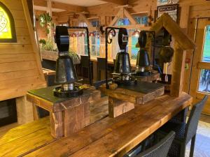 four bells sitting on a wooden table in a room at Relais Mont Jura Adults Only in Lélex