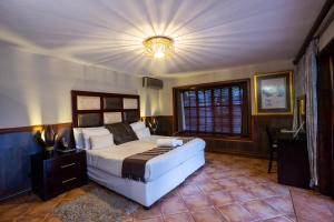a bedroom with a large bed and a chandelier at Waterfalls Boutique Hotel in Pretoria +102 photos