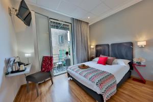 a bedroom with a large bed and a window at Hôtel Méditerranée in Calvi