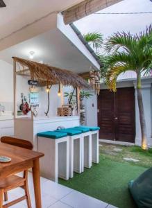 a kitchen with blue counter stools and a palm tree at Villa casa in Seminyak +1 photo