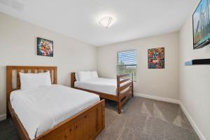 ein Schlafzimmer mit zwei Betten und einem Fenster in der Unterkunft 900 Pebble Beach Drive in Kissimmee + 63 Fotos
