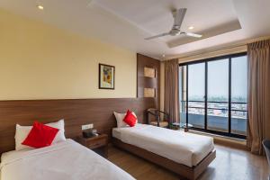 Una habitación de hotel con dos camas y una ventana. en Hotel Verandah, en Itahari