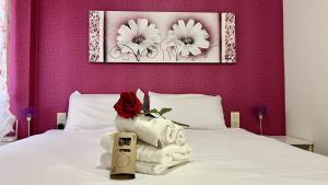 ein Schlafzimmer mit einem weißen Bett mit einer roten Rose darauf in der Unterkunft Playa mar by Gloove in San Juan de los Terreros