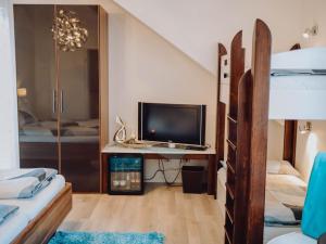 a bedroom with a desk with a television and a bunk bed at Pension Sterntaler in Rheinhausen