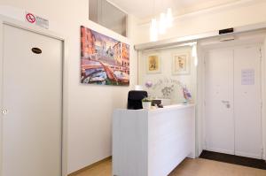 羅馬的住宿－羅馬杰梅迪旅館，白色的办公室,配有书桌和墙上的绘画