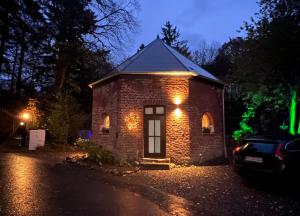 a brick house with lights on it at night at Petit Château in Eupen