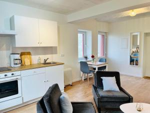 a kitchen and living room with two chairs and a table at Kranichrast in Tarmow