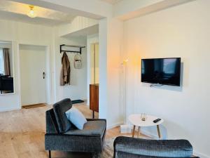 a living room with a couch and a tv on a wall at Kranichrast in Tarmow