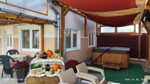 a table on the back of a house with a stage at Édenkert Apartmanház in Kisvárda