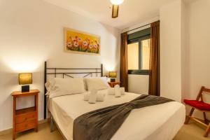 ein Schlafzimmer mit einem Bett und einem roten Stuhl in der Unterkunft Playa Marina by Ĥ - Playa Punta del Moral PPHM218P41 in Punta del moral + 18 Fotos