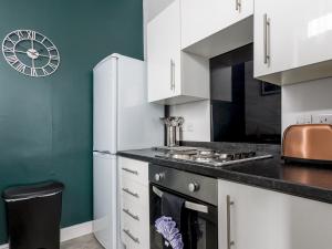 a kitchen with white cabinets and a refrigerator at Abdiel 6 · Stylish 1st-Floor Retreat by Hartlepool Marina Pass the Keys in Hartlepool