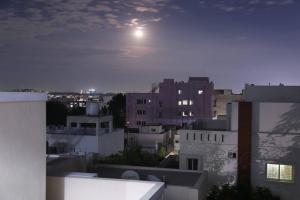 a view of a city at night with the moon at Veetil-PentHouse, 2BHK, KPHB, Hyderabad in Hyderabad
