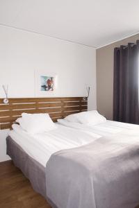 ein Schlafzimmer mit zwei Betten mit weißer Bettwäsche in der Unterkunft Hotel E-10 by First in Kiruna
