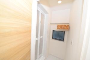 Televiisor ja/või meelelahutuskeskus majutusasutuses NYHotel 2 新宿2階建て3室1バスルーム1シャワー2トイレ