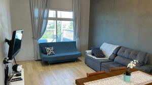 a living room with a couch and a tv at Casa piscina MAJU in Imbé +32 photos