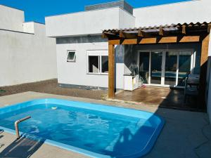 a swimming pool in the backyard of a house at Casa piscina MAJU in Imbé