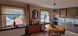 a kitchen with a table and chairs and two windows at Vakantiehuis Ykema in Eisenschmitt