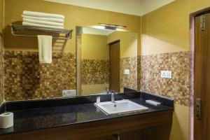 un baño con lavabo y espejo en Hotel Verandah, en Itahari 60 fotos más